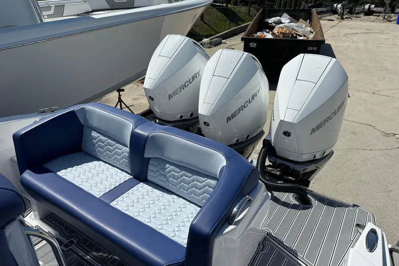 Slide: The Image of 2024 Nor-Tech 340 Sport Center Console with triple Mercury outboard engines and blue seating. - 13