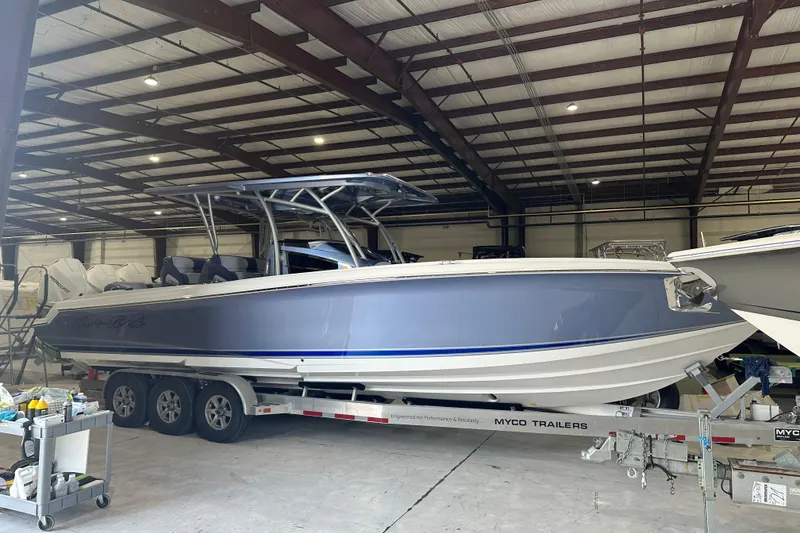 Slide: The Image of 2024 Nor-Tech 340 Sport Center Console boat in a warehouse on a trailer. - 16