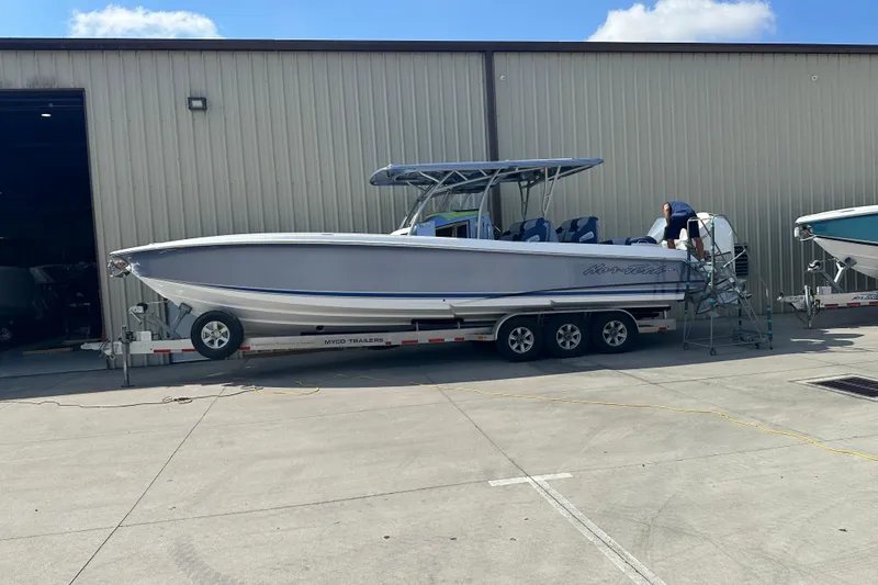 Slide: The Image of 2024 Nor-Tech 340 Sport Center Console boat on trailer outside warehouse. - 17