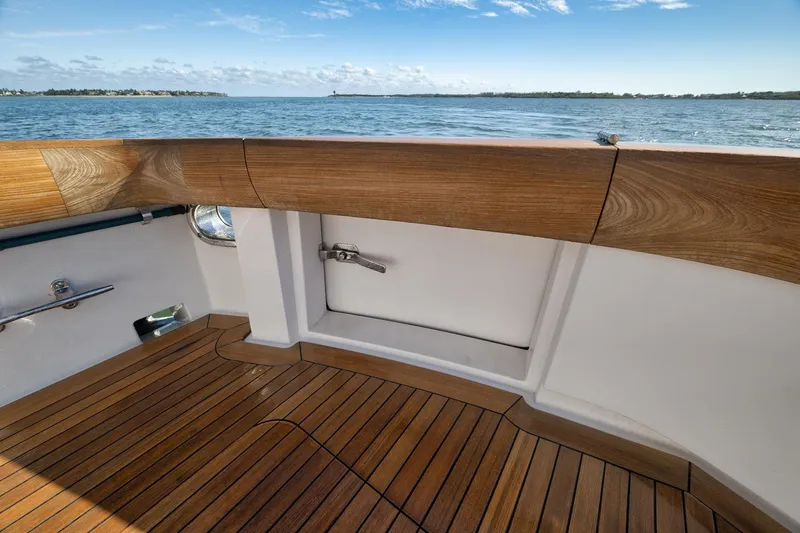 Slide: The Image of 2015 Hatteras GT70 yacht deck with wooden finish, overlooking serene ocean view. - 16