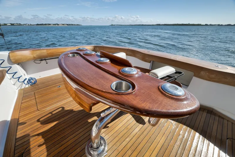 Slide: The Image of 2015 Hatteras GT70 yacht deck with wooden finish, overlooking serene ocean view. - 17