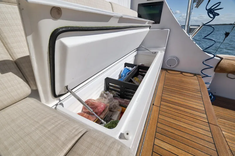 Slide: The Image of Luxurious 2015 Hatteras GT70 yacht deck with cushioned seating and wooden flooring. - 20