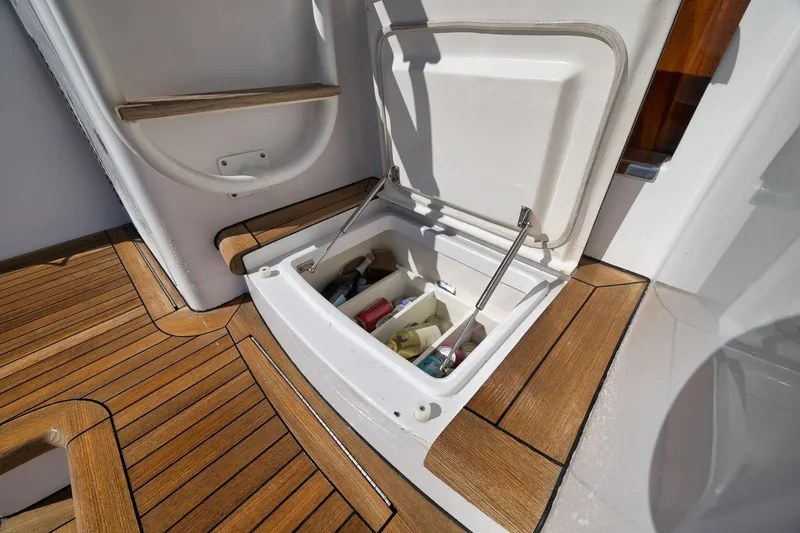 Slide: The Image of 2015 Hatteras GT70 yacht deck with storage and ladder, overlooking water. - 23