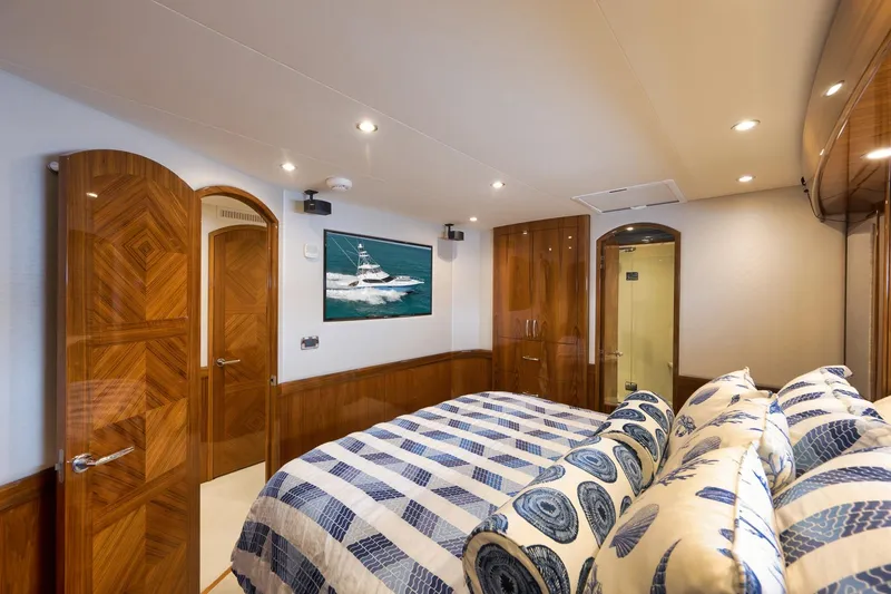 Slide: The Image of Luxurious bedroom interior of 2015 Hatteras GT70 yacht with elegant wood finishes and nautical bedding. - 41
