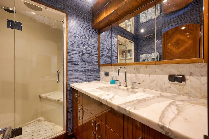 Slide: The Image of Luxurious 2015 Hatteras GT70 yacht bedroom with elegant wood finishes and nautical decor. - 43