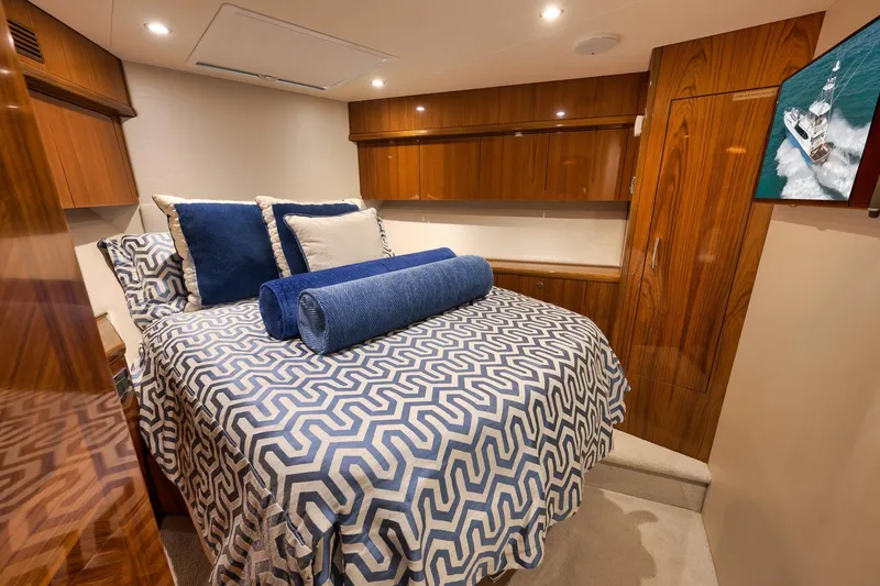 Slide: The Image of Luxurious cabin interior of 2015 Hatteras GT70 yacht with elegant wood finish and patterned bedding. - 47