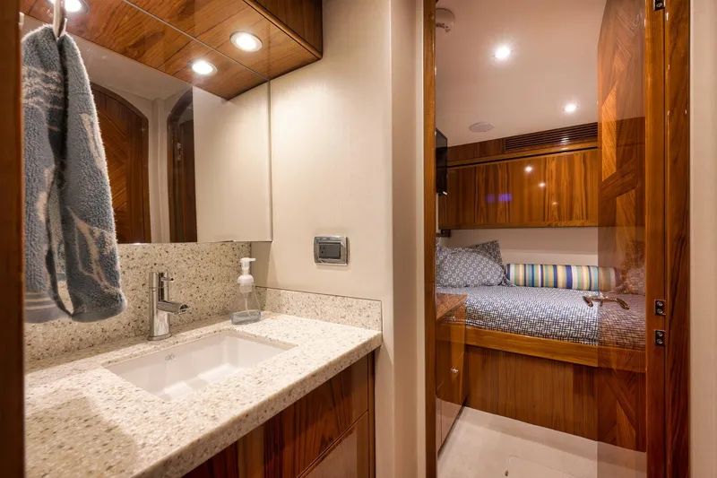 Slide: The Image of Luxurious bathroom interior of 2015 Hatteras GT70 yacht with wooden cabinetry and glass shower. - 53