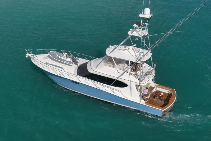 Slide: The Image of 2015 Hatteras GT70 yacht cruising through turquoise waters, rear view. - 6