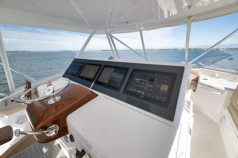 Slide: The Image of Helm of 2015 Hatteras GT70 yacht with navigation screens and panoramic ocean view. - 64