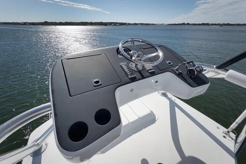 Slide: The Image of Helm of 2015 Hatteras GT70 yacht overlooking serene water and distant shoreline. - 77