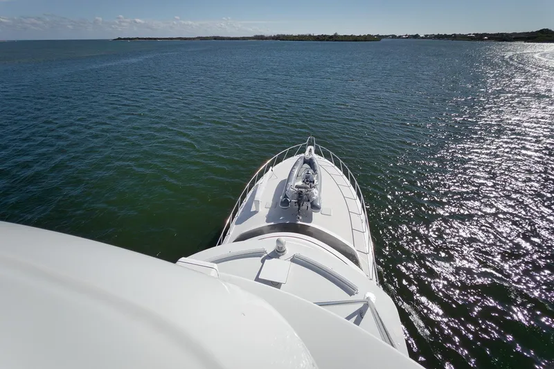 Slide: The Image of 2015 Hatteras GT70 yacht deck overlooking calm waters and distant shoreline. - 81