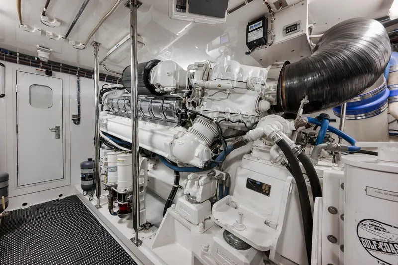 Slide: The Image of Engine room of 2015 Hatteras GT70 yacht featuring Cummins Onan generator and complex piping system. - 89