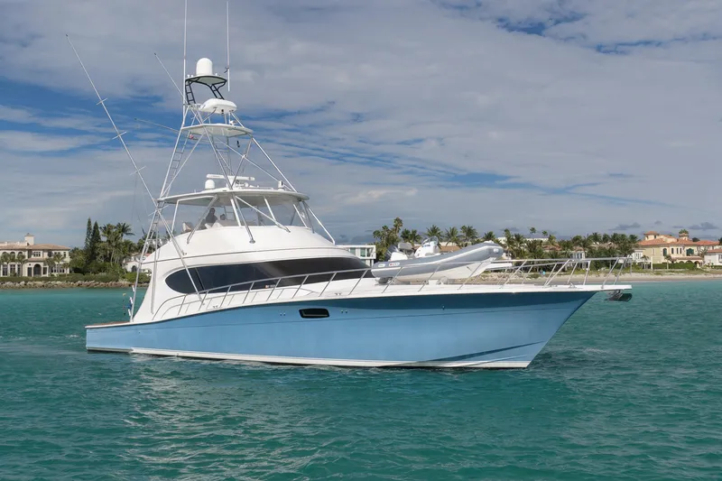 Slide: The Image of 2015 Hatteras GT70 yacht cruising in clear blue waters near a tropical shoreline. - 9