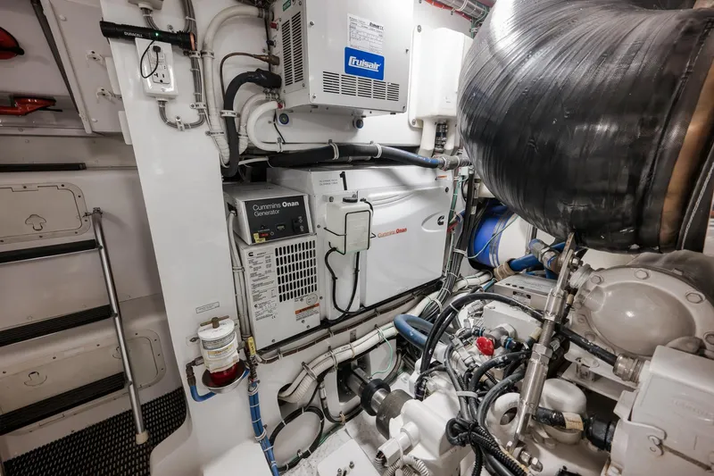 Slide: The Image of Engine room of 2015 Hatteras GT70 yacht featuring Cummins Onan generator and fire extinguisher. - 91