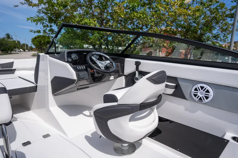 Slide: The Image of 2024 Monterey M-205 boat interior with steering wheel and seating, under clear blue sky. - 5
