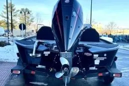 Slide: The Image of 2025 Tracker Savage 215 boat, rear view with motor, parked outdoors. - 4