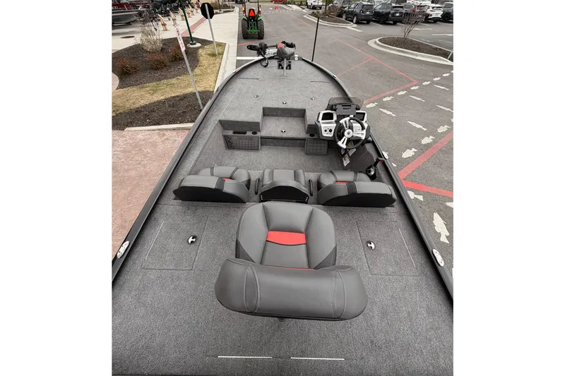 Slide: The Image of 2025 Tracker Savage 215 boat interior with gray and red seating, steering console, and storage compartments. - 7