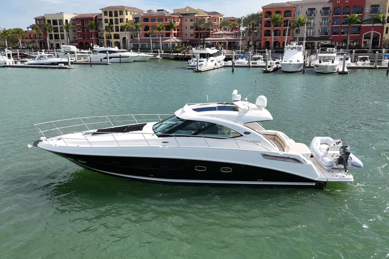 Slide: The Image of 2014 Sea Ray 470 Sundancer yacht docked in a marina with colorful buildings. - 1
