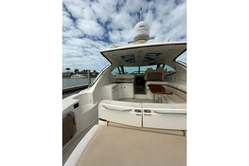 Slide: The Image of 2014 Sea Ray 470 Sundancer yacht interior with seating, table, and open sky view. - 10