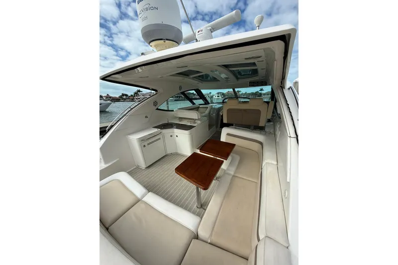 Slide: The Image of Luxurious 2014 Sea Ray 470 Sundancer yacht interior with elegant seating and wooden tables. - 14