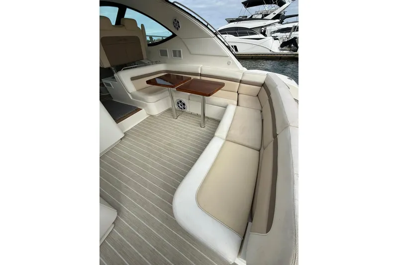 Slide: The Image of 2014 Sea Ray 470 Sundancer yacht interior with elegant seating and wooden tables. - 15
