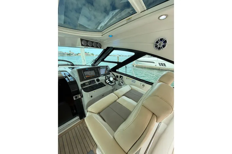 Slide: The Image of 2014 Sea Ray 470 Sundancer helm with modern controls and luxurious seating. - 27