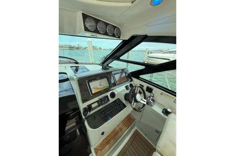 Slide: The Image of Helm of 2014 Sea Ray 470 Sundancer with modern navigation equipment and scenic marina view. - 29