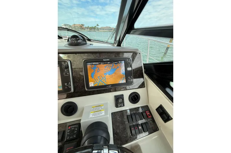 Slide: The Image of 2014 Sea Ray 470 Sundancer helm with navigation display and controls. - 32