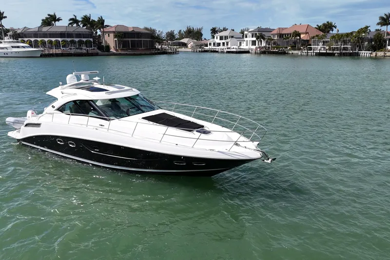 Slide: The Image of 2014 Sea Ray 470 Sundancer yacht cruising in a scenic waterfront area. - 4