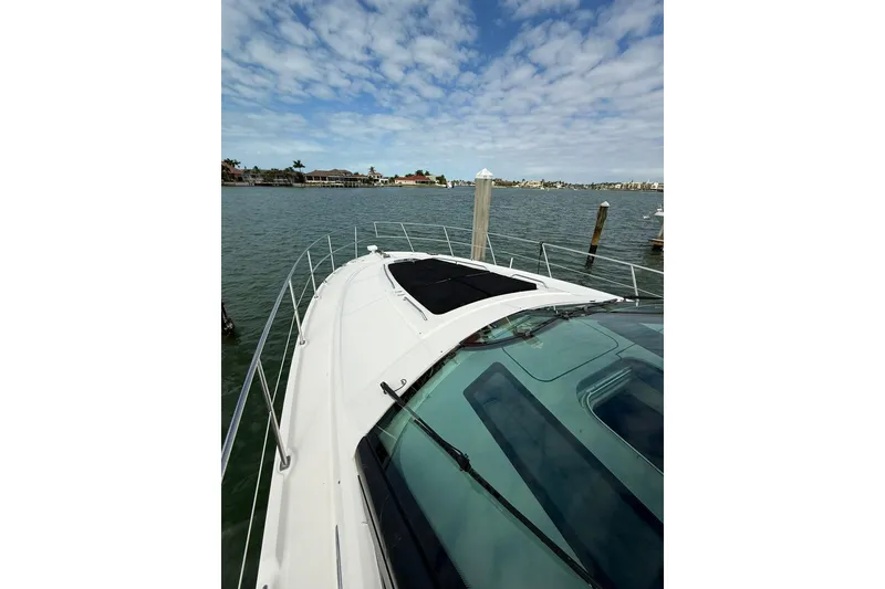 Slide: The Image of 2014 Sea Ray 470 Sundancer yacht docked with scenic waterfront view. - 42