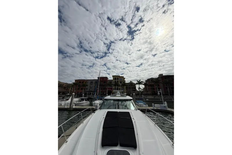 Slide: The Image of 2014 Sea Ray 470 Sundancer yacht docked under cloudy sky, with waterfront buildings in background. - 45