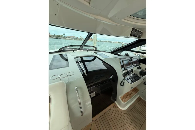 Slide: The Image of 2014 Sea Ray 470 Sundancer helm with modern navigation equipment and panoramic water views. - 48