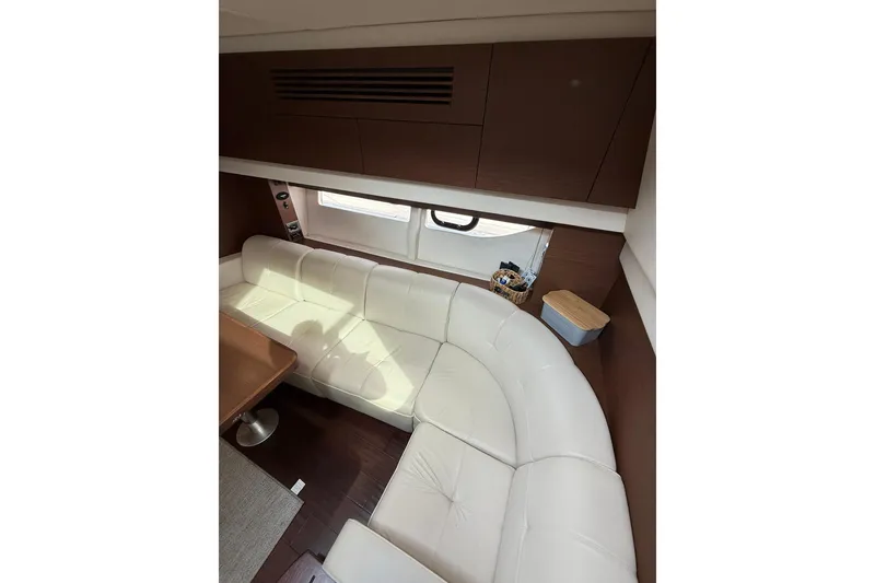 Slide: The Image of Luxurious interior of 2014 Sea Ray 470 Sundancer with white leather seating and wooden accents. - 58