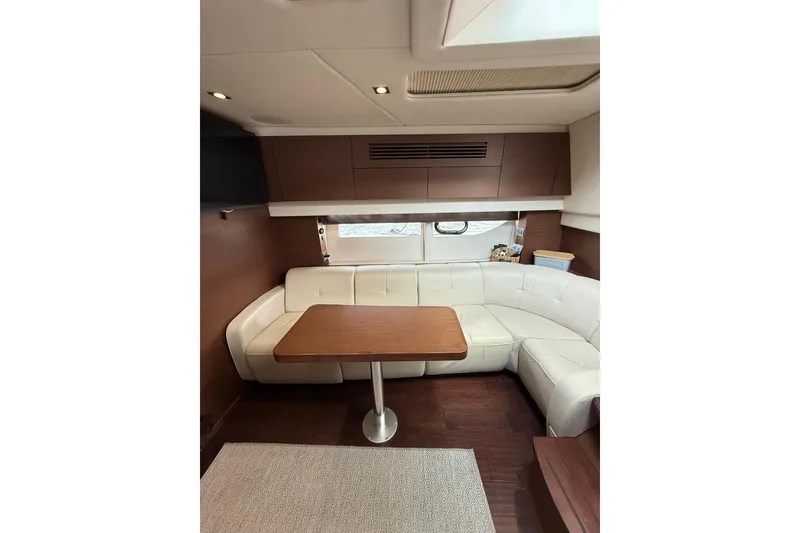 Slide: The Image of Luxurious interior of 2014 Sea Ray 470 Sundancer with white leather seating and wooden table. - 63