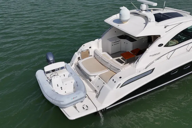 Slide: The Image of 2014 Sea Ray 470 Sundancer yacht with attached dinghy on calm water. - 7