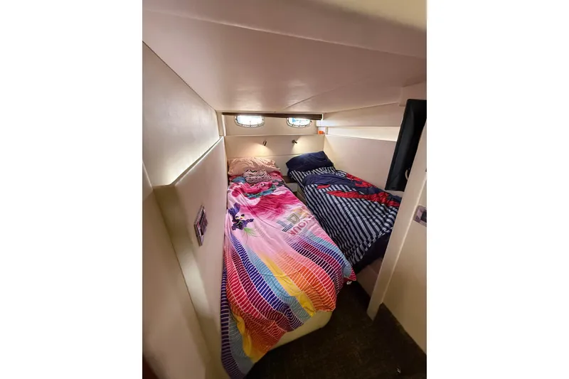 Slide: The Image of Cozy twin beds in 2014 Sea Ray 470 Sundancer cabin with colorful bedding. - 79
