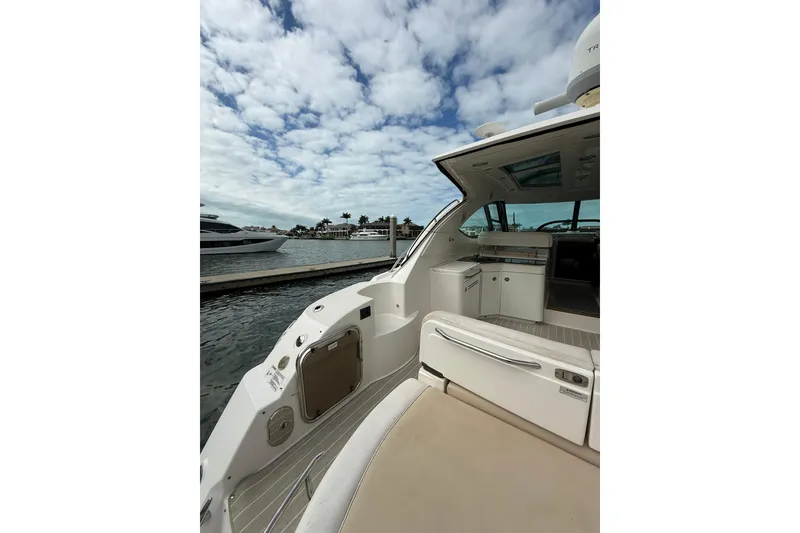 Slide: The Image of 2014 Sea Ray 470 Sundancer yacht docked, featuring spacious deck and luxurious interior. - 9