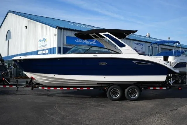 The Image of 2025 Sea Ray SDX 270 boat on trailer, parked outside dealership. - 1