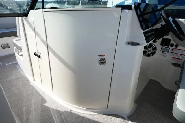 Slide: The Image of 2025 Sea Ray SDX 270 boat interior, featuring sleek white cabinetry and modern design elements. - 16