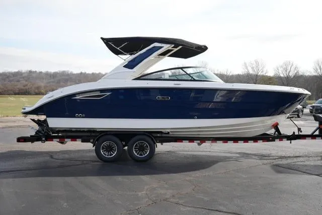 Slide: The Image of 2025 Sea Ray SDX 270 boat on trailer, blue and white design, parked outdoors. - 4