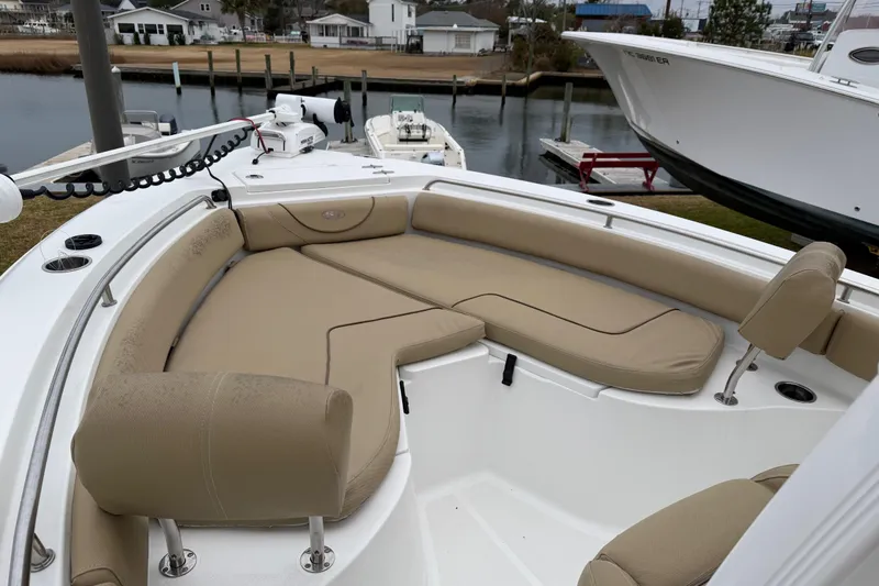 Slide: The Image of 2016 Sea Hunt Ultra 234 boat with beige seating, docked near waterfront homes. - 16