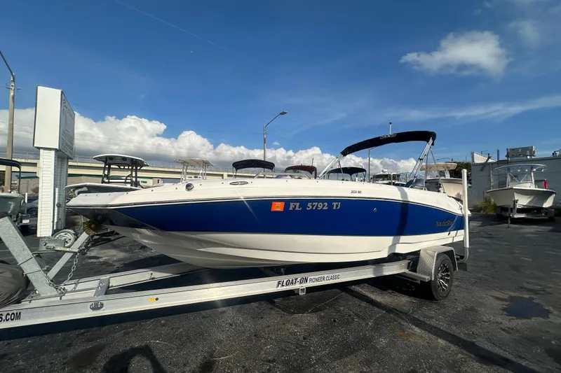 The Image of 2022 NauticStar 203 SC boat on trailer under clear blue sky. - 0
