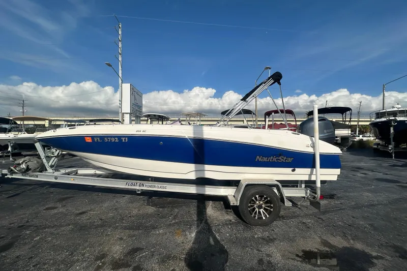 Slide: The Image of 2022 NauticStar 203 SC boat on trailer under clear blue sky. - 1