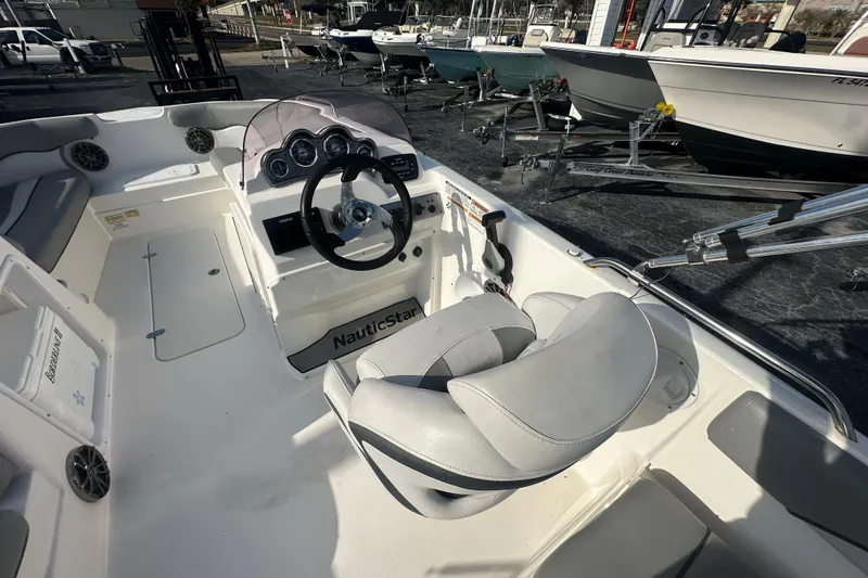 Slide: The Image of 2022 NauticStar 203 SC boat interior with steering wheel and seating. - 19