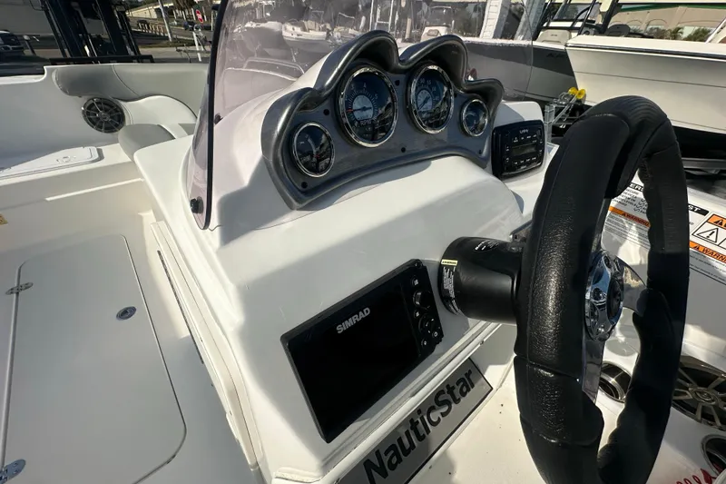 Slide: The Image of 2022 NauticStar 203 SC boat dashboard with steering wheel and gauges. - 23