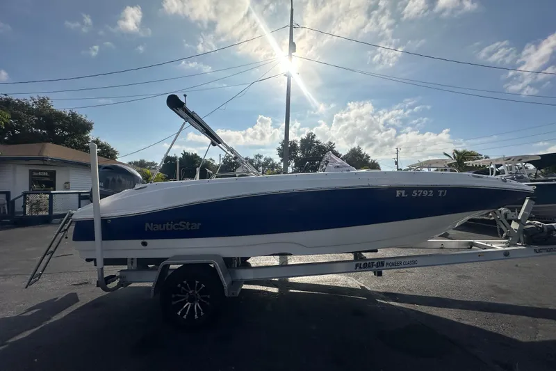 Slide: The Image of 2022 NauticStar 203 SC boat on trailer under sunny sky. - 5