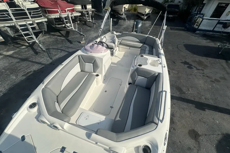 Slide: The Image of 2022 NauticStar 203 SC boat with spacious seating and modern design in a marina setting. - 9