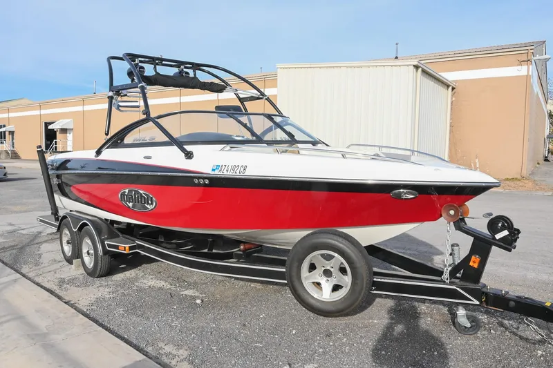 Slide: The Image of 2004 Malibu Wakesetter 23 XTi boat on trailer, red and white design, parked outdoors. - 2