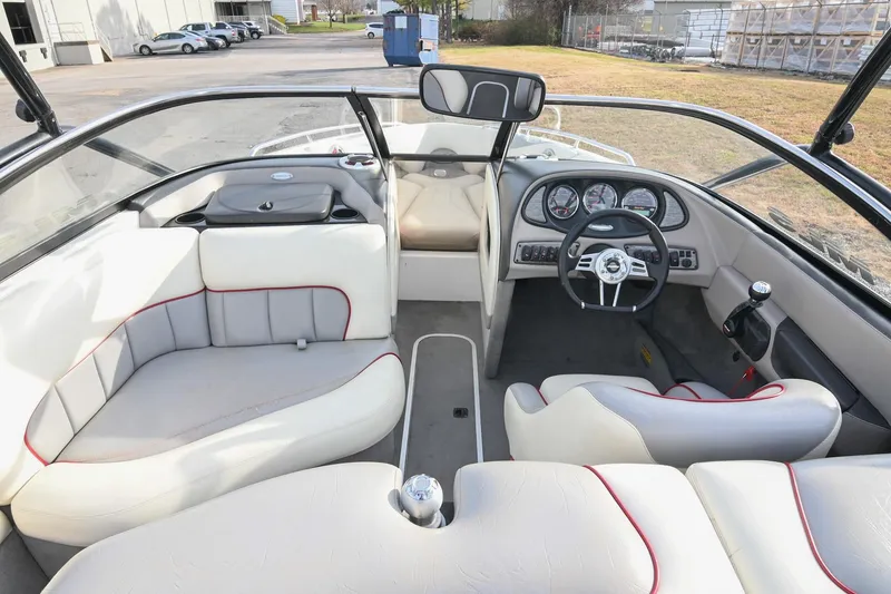 Slide: The Image of 2004 Malibu Wakesetter 23 XTi boat interior with white seating and dashboard view. - 24