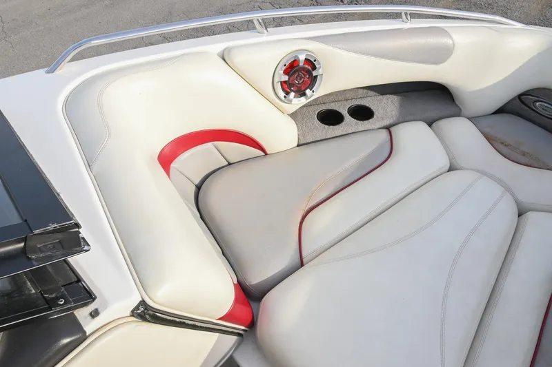 Slide: The Image of 2004 Malibu Wakesetter 23 XTi boat interior with white and red seating, speaker, and cup holders. - 37